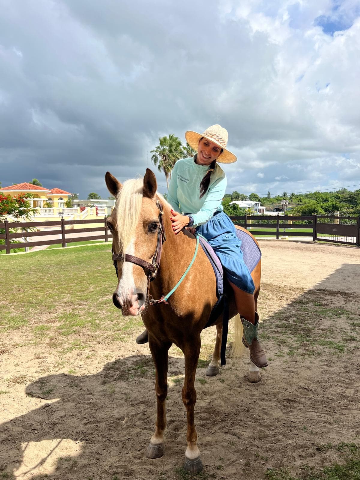 Adulta montando un caballo palomino en el picadero