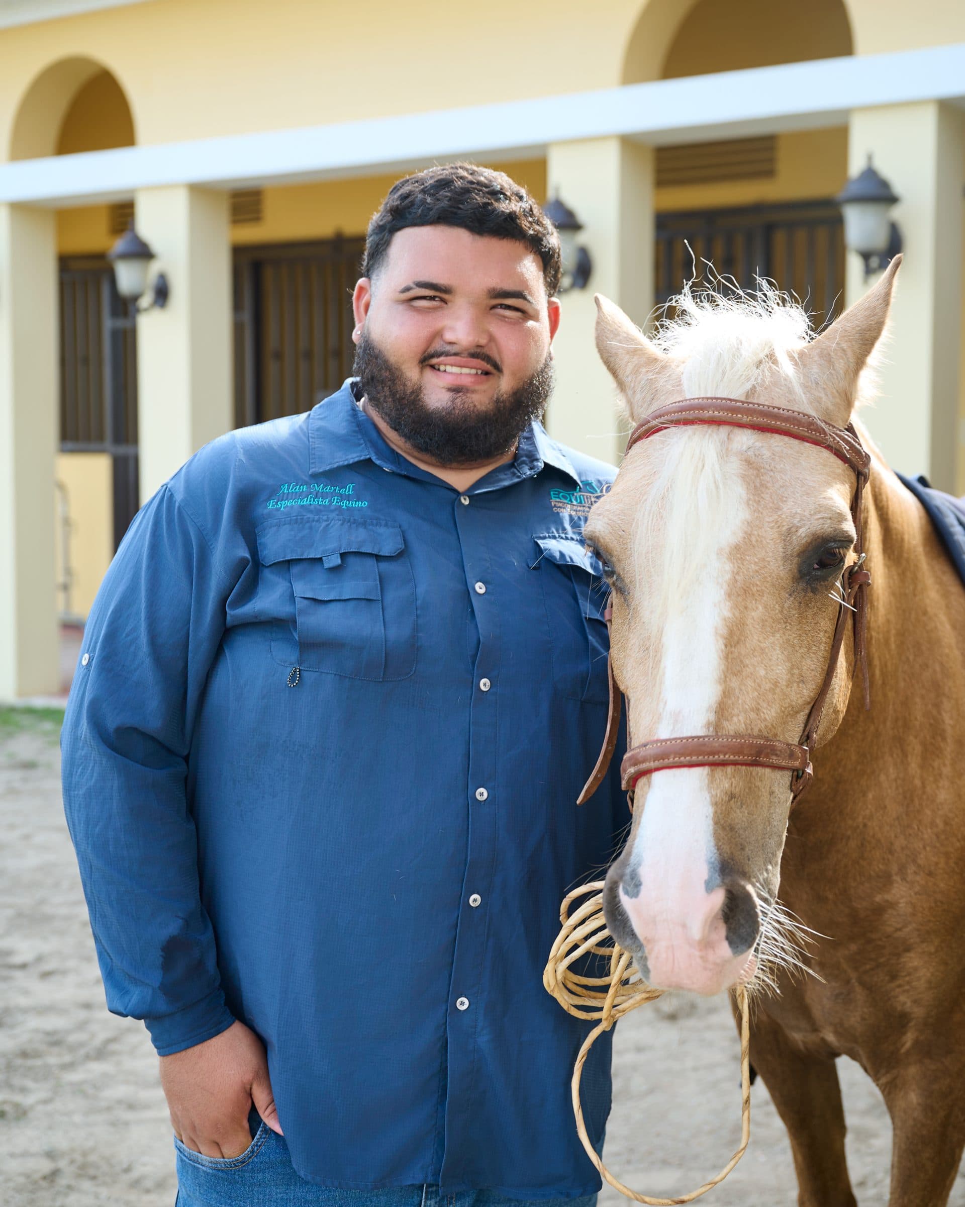 Integrante del equipo junto a un caballo palomino