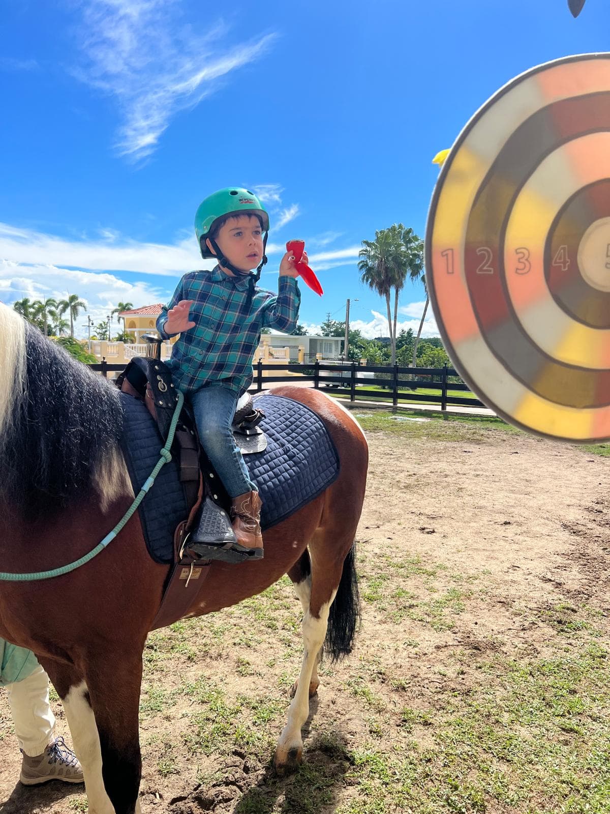 Niño a caballo lanzando un objeto hacia una diana durante una sesión