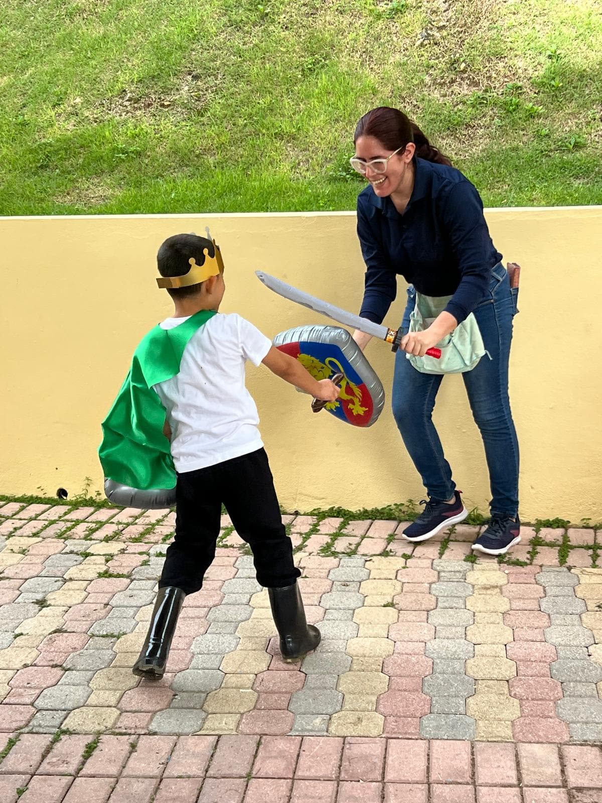 Niño con capa y corona jugando con su terapeuta durante una sesión